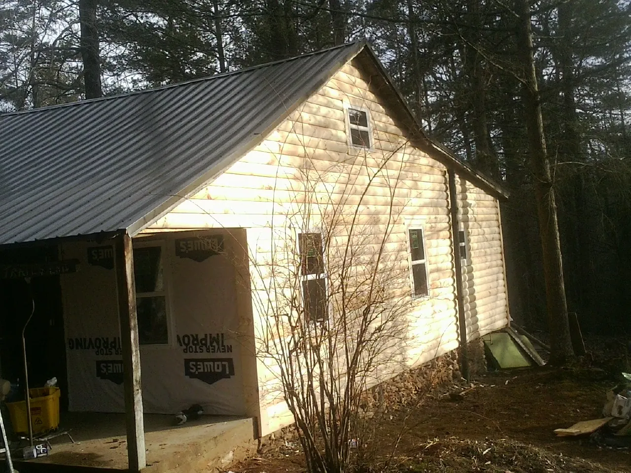 Log siding gable end under a dark metal roof edge in Fort Walton Beach
