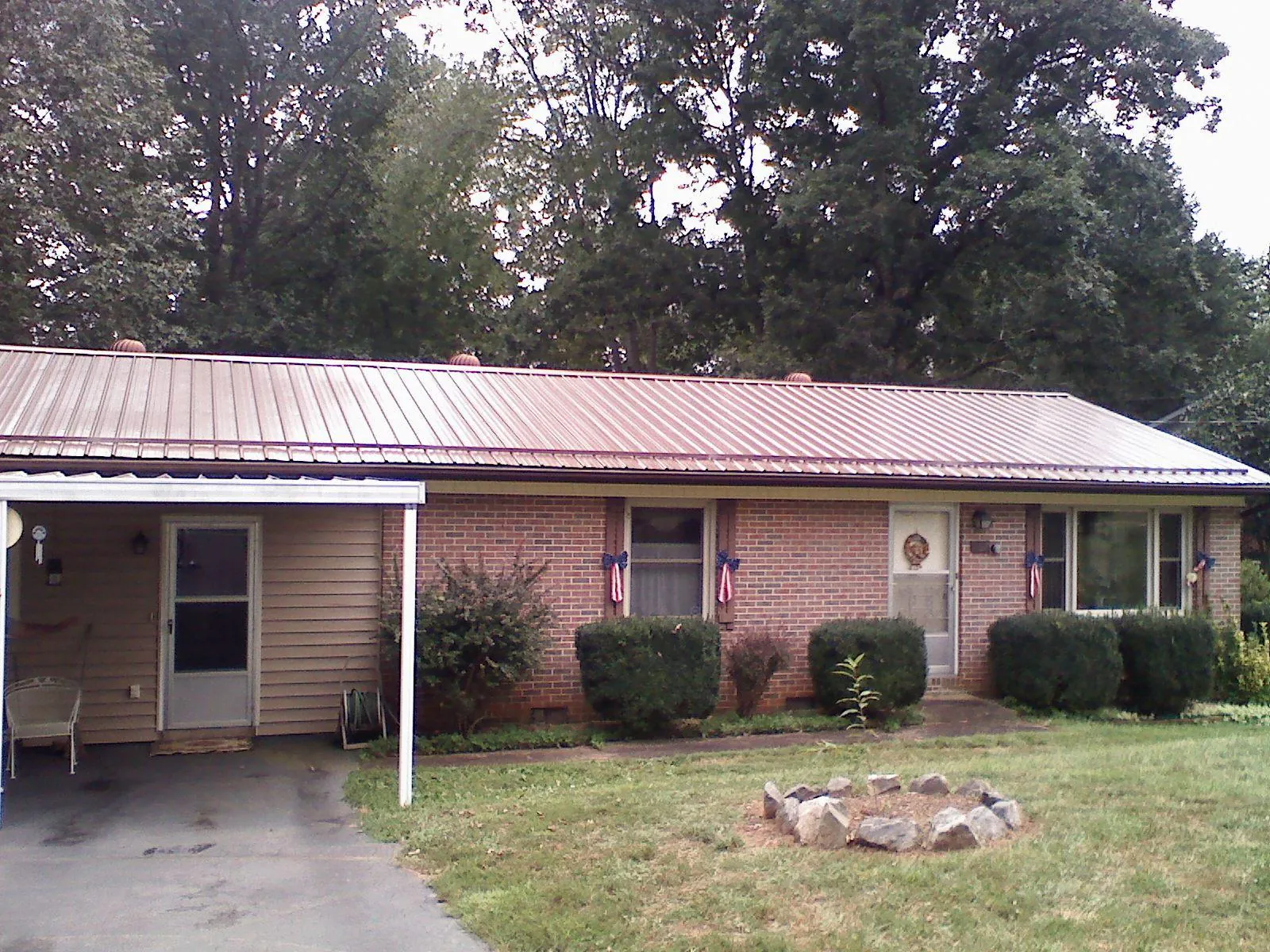 Bronze metal roof and carport on a brick ranch home — Roof Repair work by our crew in Fort Walton Beach