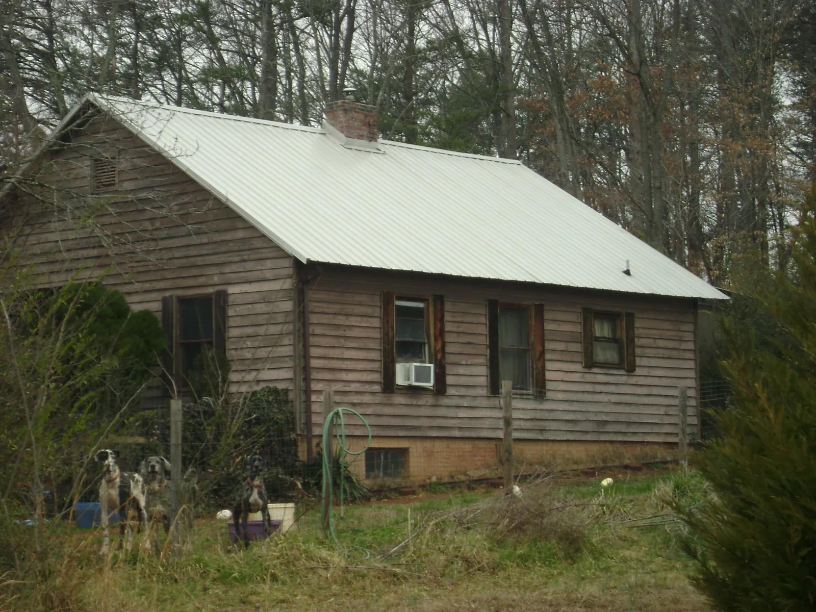 White metal roof on an old wood sided farmhouse, from a Metal Roof Installation job in Fort Walton Beach
